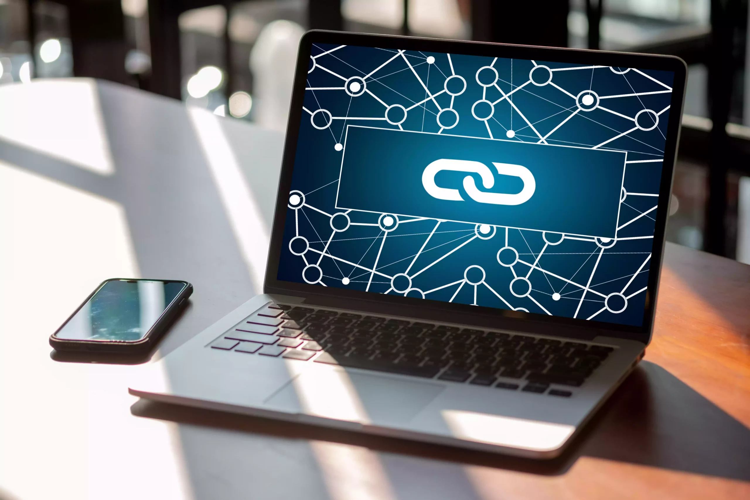 Photo d'un ordinateur portable sur lequel on voit une image d'un symbole de lien et pleins de petits points interconnectés